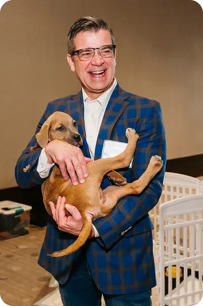 A zizzl health team member holding a puppy